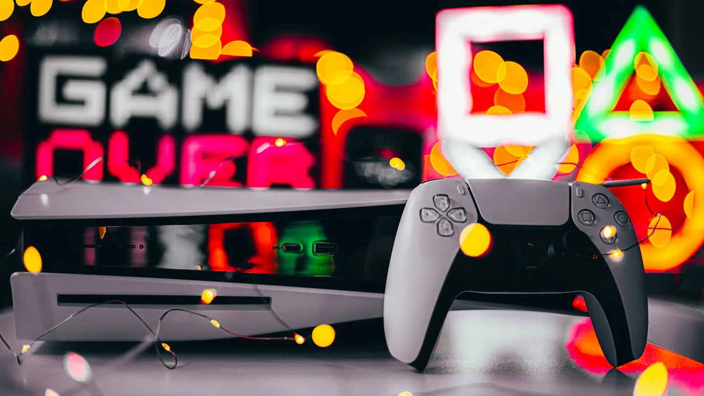 Foto ilustrativa: controle PlayStation em ambiente gamer com iluminação azul. Imagem do acervo Unsplash.